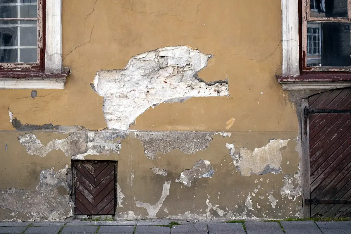 Typisches Schadensbild: abgeplatzter Außenputz an einer feuchten Fassade