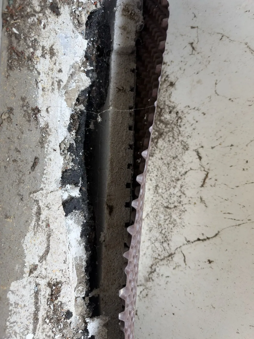 Draufsicht auf Wand mit Putzresten, Bitumen, Dämmung und Noppenbahn