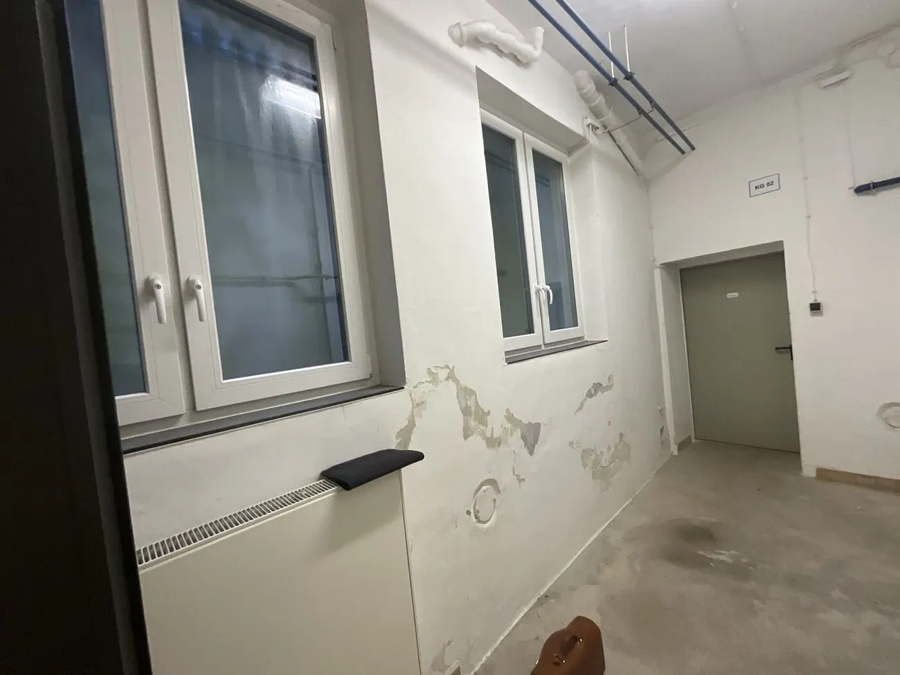 Flur im Untergeschoss mit Abplatzungen unter den Fenstern