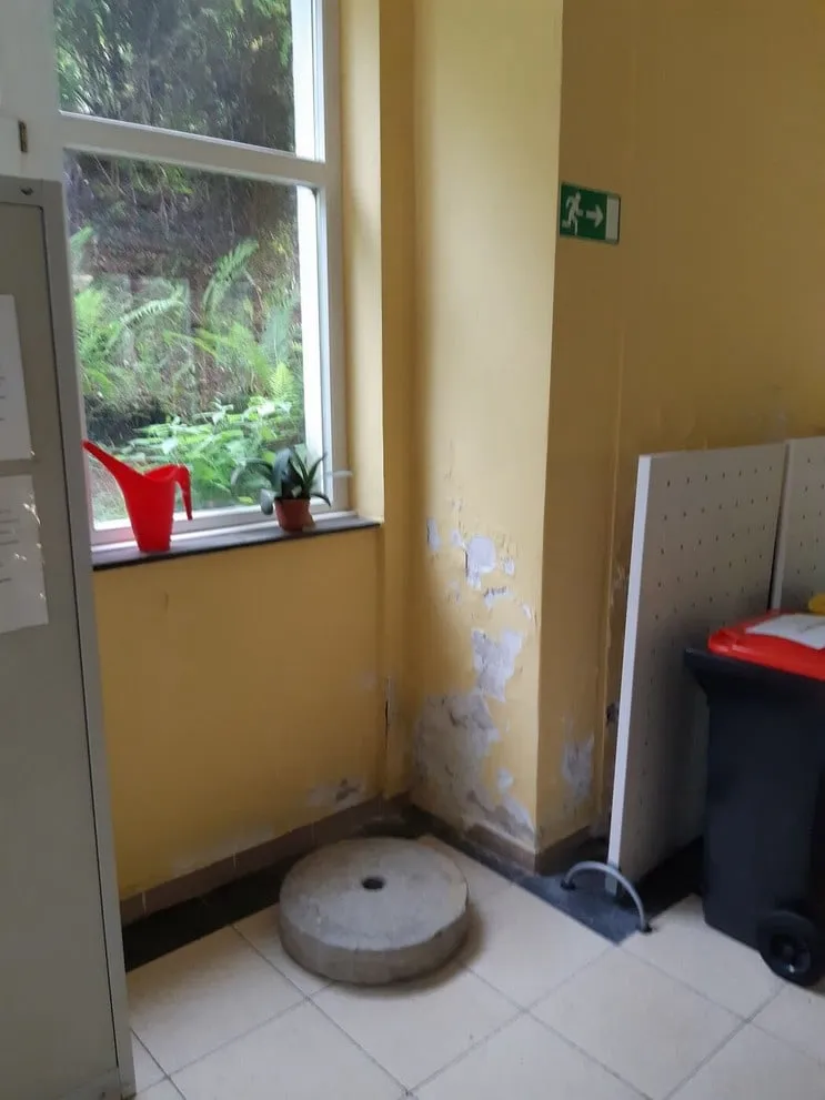 Gelb gestrichene Raumecke mit abgeplatzter Farbe am Sockel